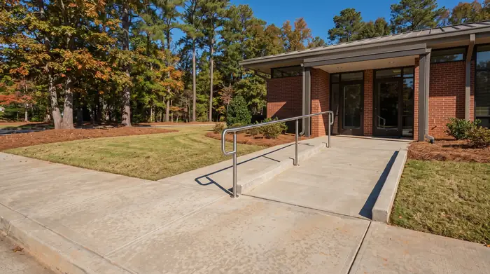 Concrete entry walk and ADA ramp at a medical office building in Marietta, GA, in clear late-morning sun.