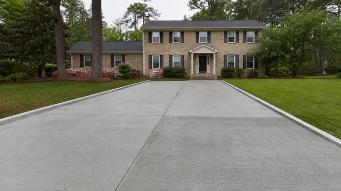 concrete slab repair completed by a local contractor at a tan-brick colonial in Marietta, GA, under an overcast sky.