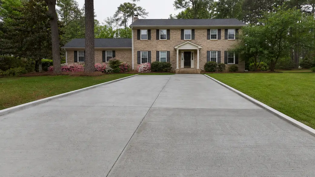 concrete slab repair completed by a local contractor at a tan-brick colonial in Marietta, GA, under an overcast sky.